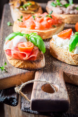 Healthy mix of bruschetta for a snack on wooden table