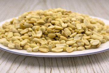 Salted roasted peanuts in a wooden bowl .