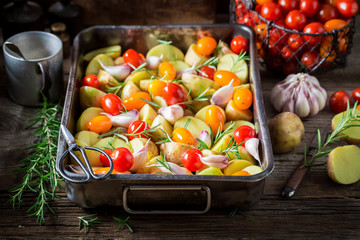 Ingredients for roasted potato with tomatoes, garlic and rosemary