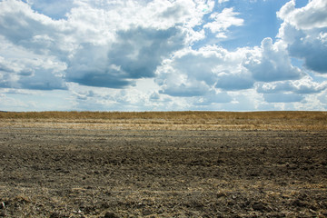 Plowed field and clouds in the sky