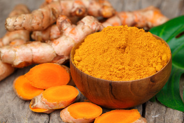 Turmeric powder in wooden bowls on wooden table