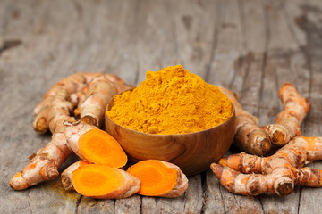 Turmeric powder in wooden bowls on wooden table