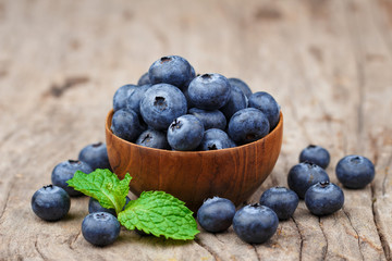 Blueberries in a wood bowl on a wooden table, Healthy eating and nutrition concept