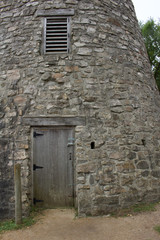 Wood plank entrance door to a very old round stone tower grist mill (windmill)