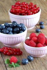 Himbeeren, blaubeeren und rote Johannisbeeren in den Schälchen