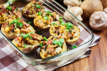 Baked potatoes in jacket stuffed with bacon, mushrooms and cheese. Dish served in baking dish..Baked potatoes stuffed with bacon, mushrooms and cheese