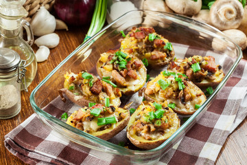 Baked potatoes in jacket stuffed with bacon, mushrooms and cheese. Dish served in baking dish..Baked potatoes stuffed with bacon, mushrooms and cheese