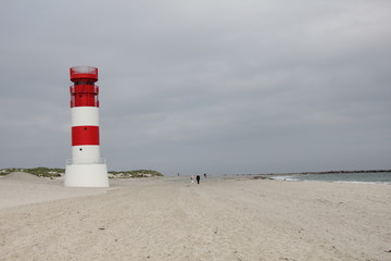 Beach on D&uuml;ne with red-white lighthouse, Heligoland, Germany.