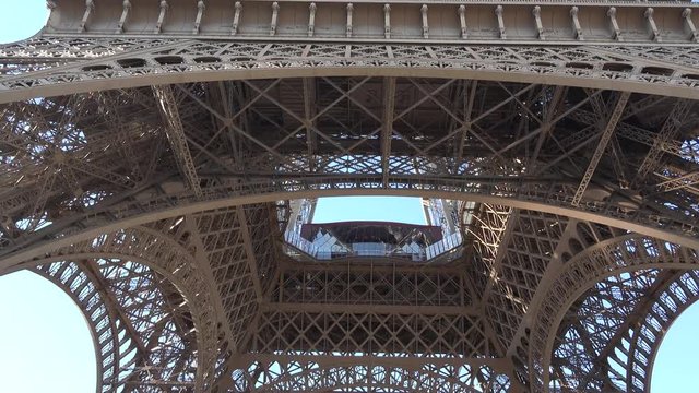 Eiffel tower and blue serene sky, looking up to Paris famous art structure