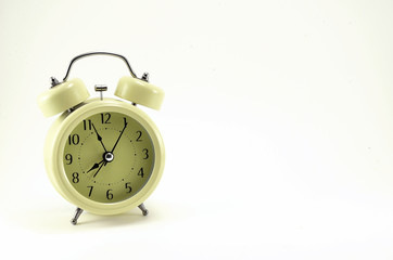 Beige alarm clock, stylized antique with black arrows.
