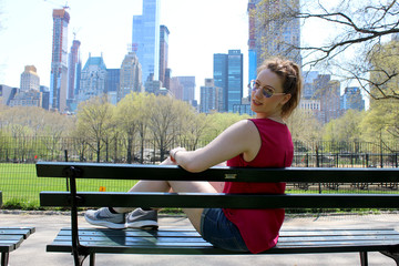 Junge Frau im Central Park mit Blick auf die New Yorker Skyline