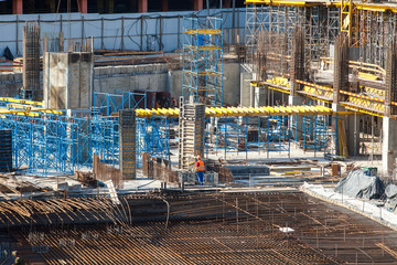 Construction of a large multi-storey commercial building. Builders work in overalls on the site...