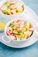 Salad with prawns in bowls on table