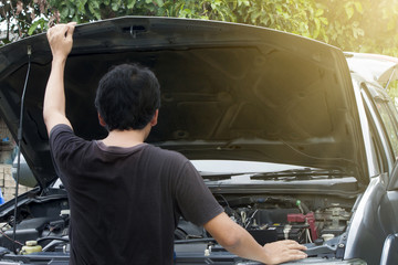 Asia man checking and maintenance engine of car by lift cover front skirt.