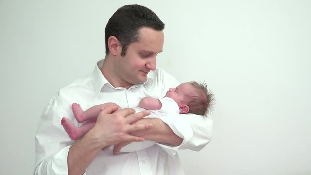 Young father standing and holding newborn in his arms