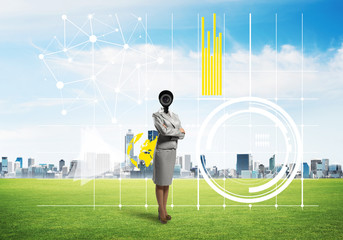 Camera headed woman standing on green grass against modern cityscape