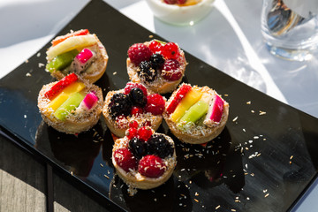 Assorted fruits and berries tartlets on wedding