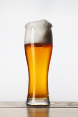 a glass of beer with foam