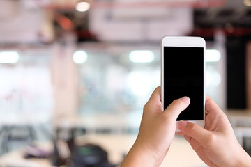 Mock up smartphone on hands with blur background.