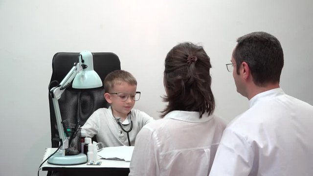 Little child doctor write a receipt for parents patients, family therapy , listen child for health and harmony