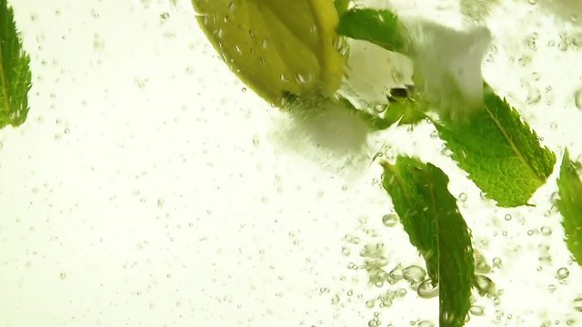 Close up ice cubes, mint leaves, lemon in mojito