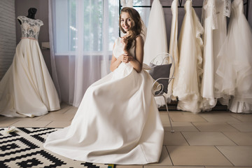 beautiful woman in wedding shop trying on a dress