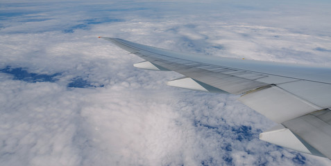 Wing of an airplane flying above the clouds.