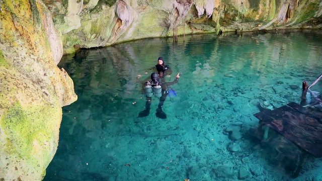 Дайверы плывут под водой в голубом озере пещера мечты ворота Сенот возле Дос Охос, Мексика.