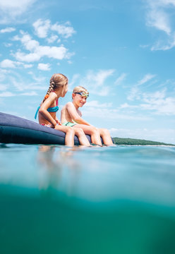 Two childs have a fun when swim on inflatable mattress in the sea lagoon