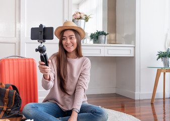 Asian young female blogger recording vlog video with mobile phone live streaming when travel.online influencer on social media viral concept. - Powered by Adobe