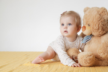 Cute baby girl with her teddy bear 