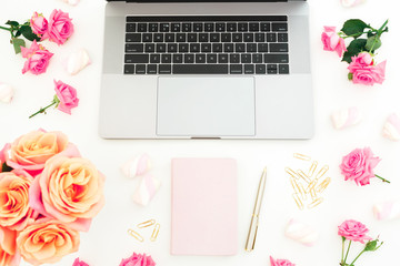 Laptop, diary, roses flowers, marshmallow and accessories on white background. Flat lay. Top view. Freelancer concept