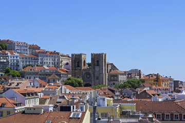 Fototapeta na wymiar The view of the city from view point. The roofs of the houses. The Lisbon Cathedral Santa Maria Maior de Lisboa or Se de Lisboa. Portugal.