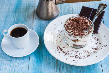 Delicious dessert tiramisu and a cup of coffee on a shabby blue wooden background