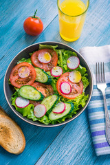Healthy vegetarian breakfast - vegetable salad, toast and a glass of orange juice