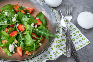 Salad with spinach, strawberries, arugula and cheese.