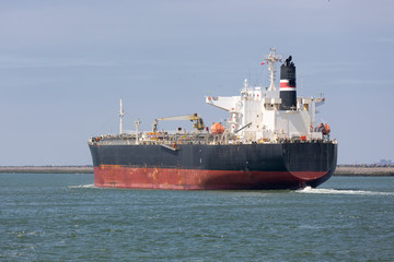 Fototapeta premium Cargo ship sailing out of Dutch harbor Rotterdam, biggest seaport of Europe