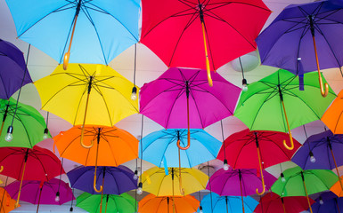 Fototapeta na wymiar A lot of multicolored umbrellas at the street