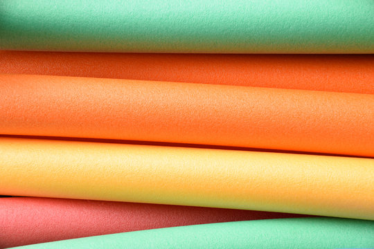 colorful pool noodles in different pastel colors, pool or therapy or swim noodles in modern colors detail shot