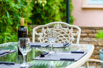 Clean tableware and a bottle of wine on a table