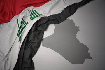waving colorful national flag and map of iraq.
