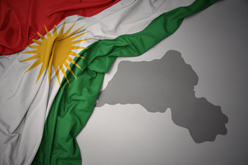 waving colorful national flag and map of kurdistan.