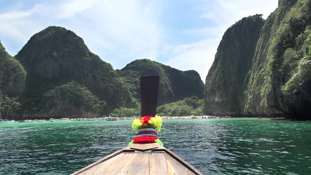 Traditional wooden long-tail boat enters Maya Bay in Phi Phi Islands, Andaman Sea, Thailand