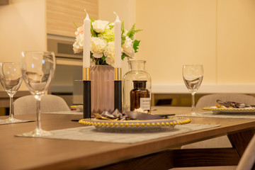 Dinner set with candles and glasses - details of the dining room