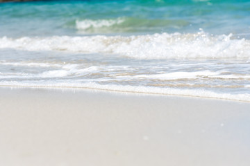 Fototapeta na wymiar Soft Wave Of Blue Ocean On Sandy Beach in summer. Background. Selective focus.