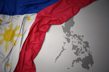 waving colorful national flag and map of philippines. © luzitanija