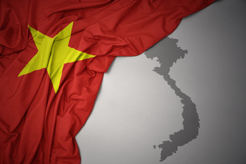 waving colorful national flag and map of vietnam.