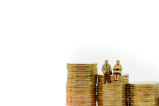 Miniature people : Couple oldman sitting with stack of coins,Business concept.