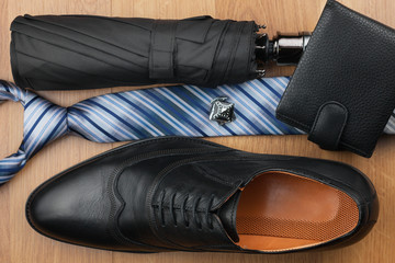 Top view, chic classic men's shoes, tie, wallet, umbrella and cufflinks