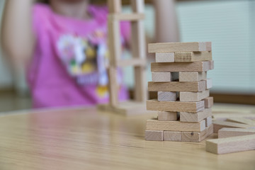 the kid play wooden blocks game , make tower in the preschool.